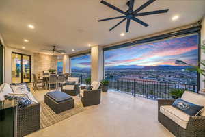 Patio terrace at dusk featuring a patio area, a ceiling fan, a mountain view, and an outdoor living / dining area