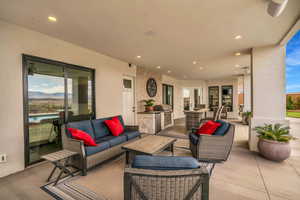 View of patio featuring french doors, a mountain view, and an outdoor kitchen with living area