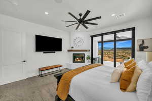 Carpeted bedroom with a ceiling fan, a brick fireplace, access to outside, and recessed lighting