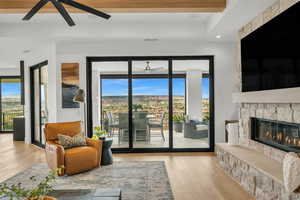 Living area featuring a ceiling fan, wood finished floors, recessed lighting, a stone fireplace, and plenty of natural light
