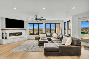 Living area featuring wood finished floors, recessed lighting, ceiling fan, and a glass covered fireplace