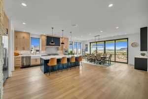 Kitchen featuring decorative light fixtures, a kitchen bar, a kitchen island, and backsplash