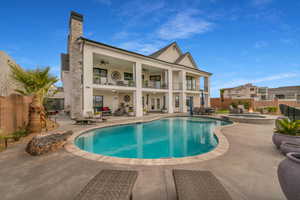 Back of property featuring ceiling fan, a balcony, and a patio