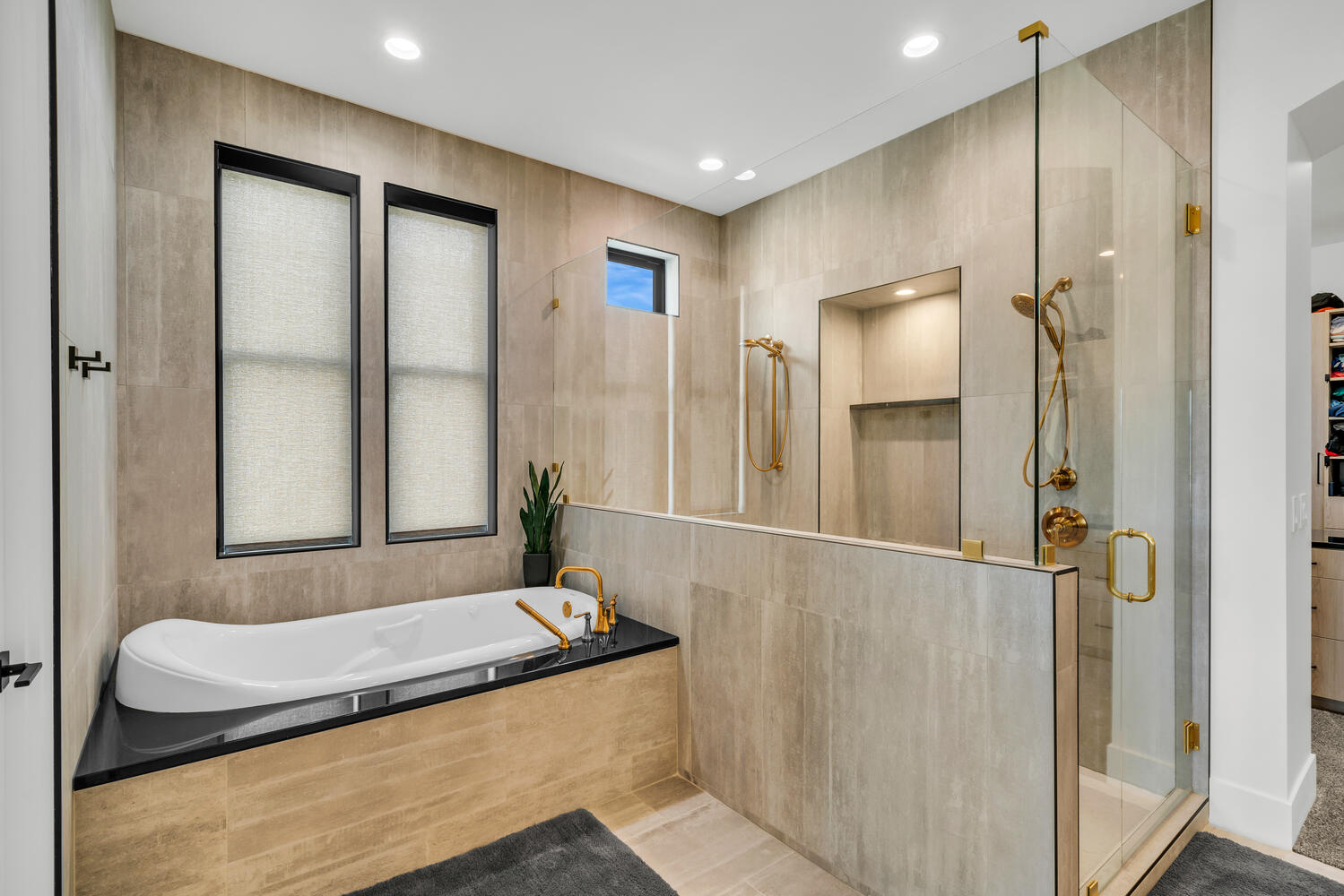 Bathroom with a shower stall, a garden tub, tile walls, recessed lighting, and a walk in closet