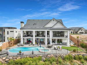 Rear view of house featuring a fenced backyard, a patio, outdoor seating, and stucco siding