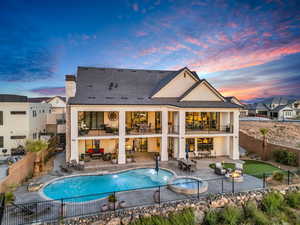 Back of house featuring outdoor seating, a fenced backyard, a pool with connected hot tub, and a patio