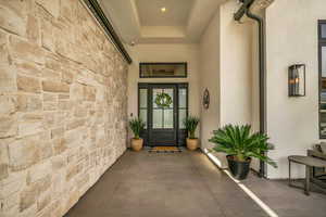View of exterior entry featuring stone siding and stucco siding