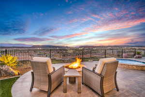 Patio terrace at dusk with a fire pit, a patio area, and a fenced backyard