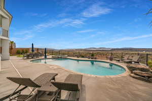 Relaxing pool / spa featuring a patio, a mountain view, and a fenced backyard