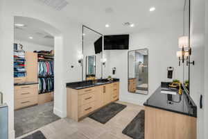 Bathroom featuring a walk in closet, vanity, recessed lighting, an enclosed shower, and light colored carpet