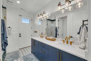 Bathroom with double vanity, a stall shower, and recessed lighting