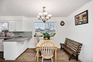 Dining space with a chandelier, laminate wood floors, and large window