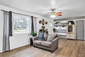 Living room featuring a ceiling fan and laminate wood finished floors