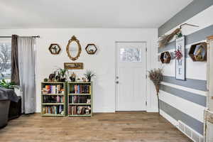 Foyer entrance with light laminate wood flooring and plenty of natural light