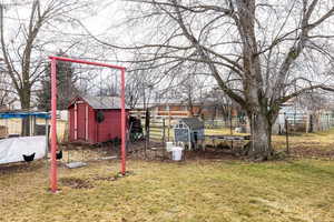 View of yard with swing set and a shed