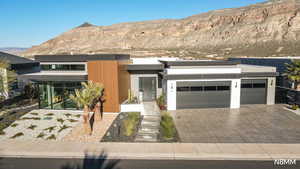 Contemporary house with a mountain view, driveway, and an attached garage