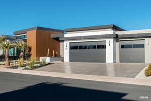 Modern home featuring an attached garage and concrete driveway