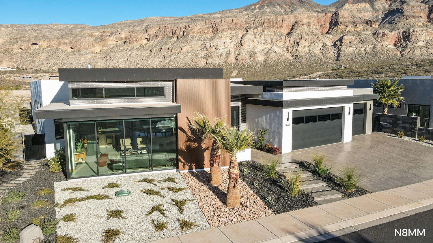 Contemporary house with driveway, a mountain view, and a garage.