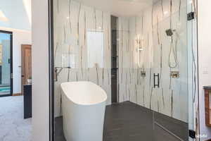 Bathroom featuring a soaking tub and a marble finish shower
