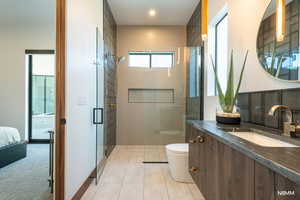 Full bath with a shower stall, vanity, and light tile patterned floors
