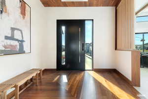 Grand entryway featuring dark wood finished floors, and healthy amount of natural light