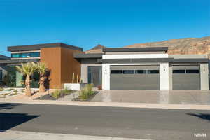 Modern home featuring concrete driveway and a garage