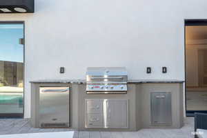View of patio featuring area for grilling by the pool