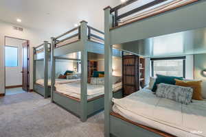 Bunkie bedroom with recessed lighting and attached bath.