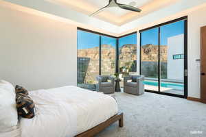 Bedroom featuring carpet flooring, a mountain view, ceiling fan, access to the pool area, and a raised ceiling