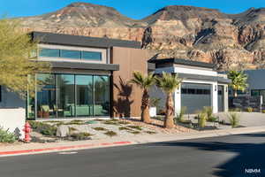 View of front of home with a mountain view and driveway