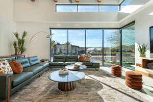 Living area with a high statement windows and ceiling