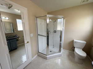 Bathroom featuring a shower stall, a textured ceiling, and vanity