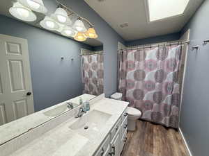 Full bathroom featuring vanity, a shower with curtain, and dark wood finished floors