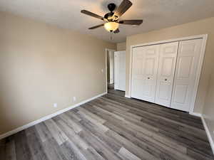 Unfurnished bedroom featuring a ceiling fan, light wood finished floors, a closet, and a textured ceiling