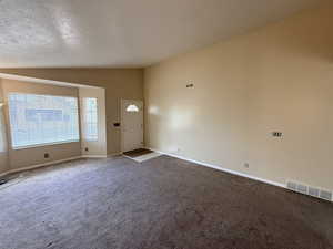 Carpeted foyer entrance featuring baseboards