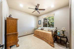 Carpeted bedroom with a ceiling fan and recessed lighting