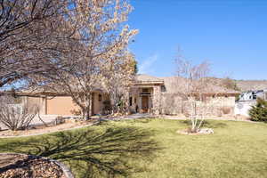 View of front of house featuring a front lawn, a garage, stucco siding, and driveway