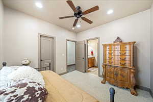 Carpeted bedroom featuring ceiling fan, ensuite bathroom, and recessed lighting