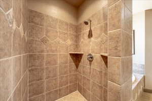 Bathroom featuring tiled shower and tiled tub