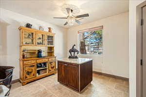 Office space featuring baseboards and ceiling fan