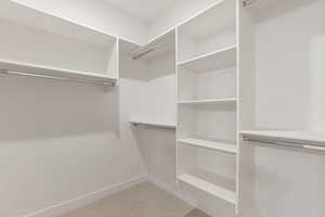 Walk in closet with light colored carpet