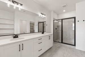 Bathroom with a spacious closet, double vanity, a stall shower, and recessed lighting