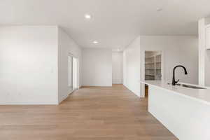 Corridor with light wood-style floors and recessed lighting