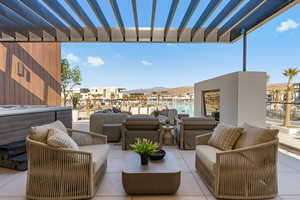 View of patio featuring outdoor furniture, a pergola, a mountain view, and a hot tub