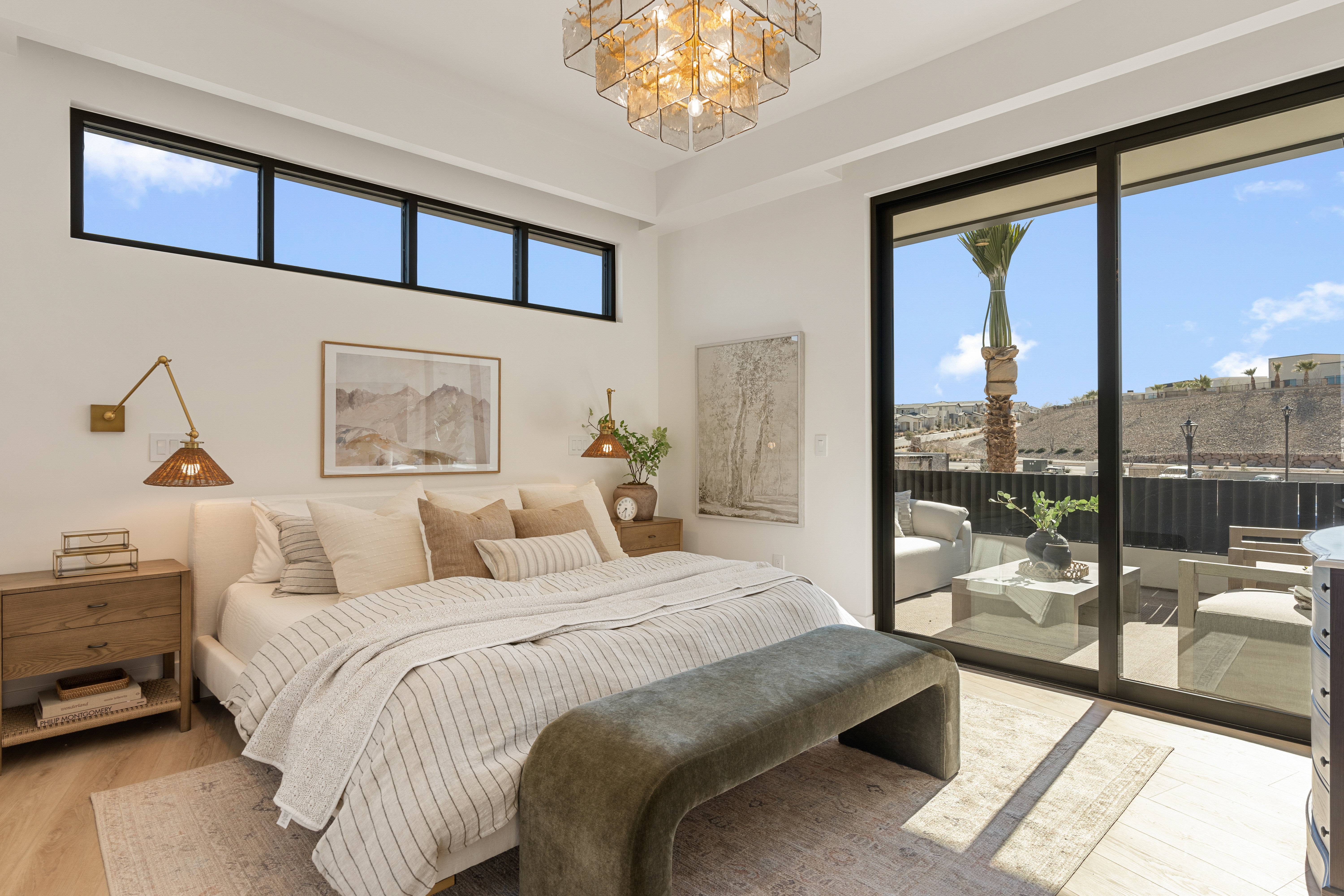 Bedroom featuring hanging lights, light wood-style floors, multiple windows, and access to exterior