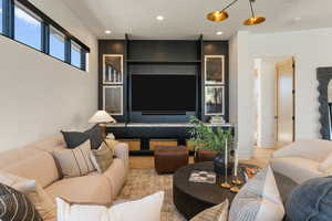 Living room with light wood-type flooring and recessed lighting