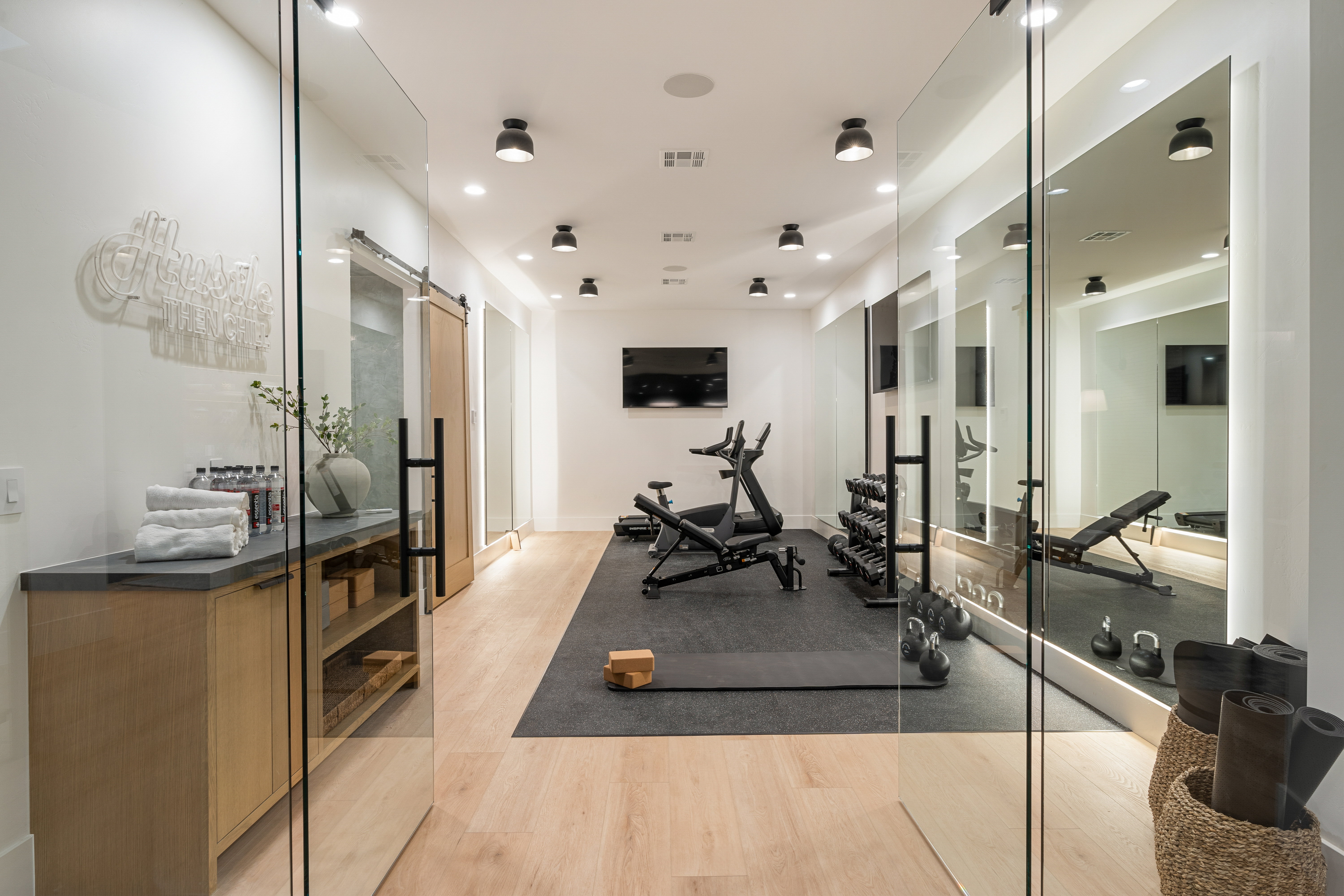 Exercise area featuring a barn door, light wood-style floors, and recessed lighting