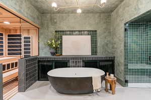 Bathroom with a sauna, a stall shower, and a soaking tub