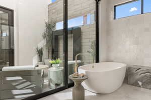 Bathroom featuring a freestanding bath, tile walls, and tile patterned flooring