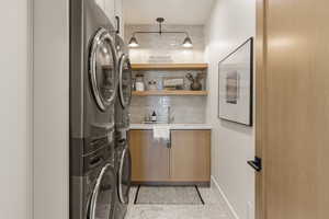 Laundry room featuring stacked washing machine and dryer and cabinet space